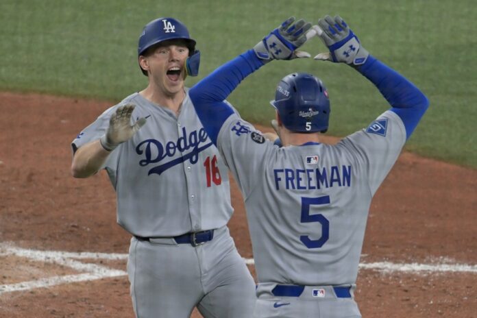 El jugador Will Smith (i) celebra con Freddie Freeman (d) tras conectar un jonrón solitario para allanar el título por segundo año consecutivo de los Dodgers de Los Angeles en la Serie Mundial decidida sobre los Azulejos este sábado en Toronto. EFE/EPA/EDUARDO LIMA