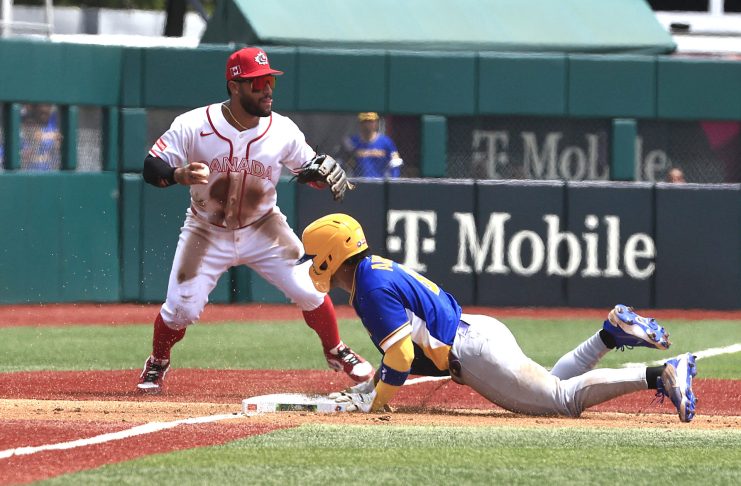 El colombiano Michael Arroyo (d) se desliza en tercera base ante el canadiense Abraham Toro durante el juego del Clásico Mundial de Béisbol de este sábado en el estadio Hiram Bithorn de San Juan. EFE/ Thais Llorca