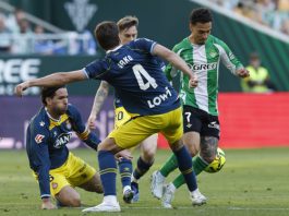 El delantero brasilero del Betis Antony (d) disputa un balón ante el centrocampista del Espanyol Urko González (c) durante el encuentro correspondiente a la jornada 30 de Laliga EA Sports que disputan este sábado Real Betis y RCD Espanyol en el estadio de La Cartuja, en Sevilla. EFE / Julio Muñoz