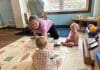 Hay que replantear el cuidado infantil de Estados Unidos. Una empleada del centro de cuidado infantil Cubby’s Childcare Center in Bridgeport, Virginia Occidental, juega con dos bebés durante el mes de julio. Un grupo bipartidista de legisladores estatales afirma que es hora de replantearse el frágil sistema de cuidado infantil del país. (Foto de Amelia Ferrell Knisely/West Virginia Watch)