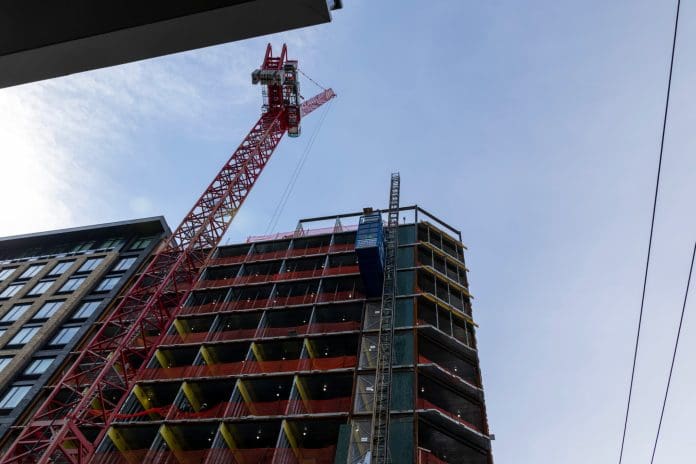 La construcción de un nuevo edificio residencial en Jersey City. La oferta de trabajadores calificados en la construcción y otros oficios está bajo presión por el envejecimiento, la aplicación de las leyes de inmigración y la prisa por construir centros de datos. (Foto de Anne-Marie Caruso/New Jersey Monitor)