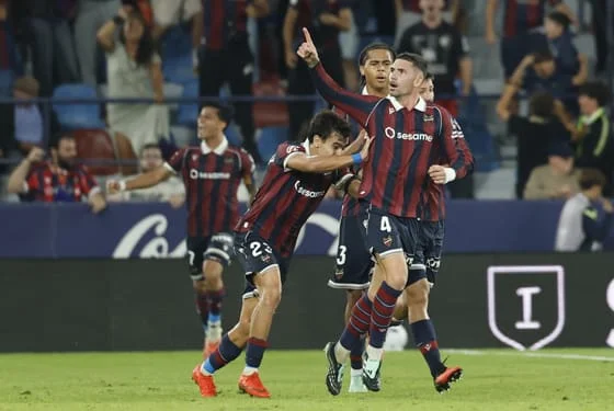 El defensa del Levante Adrián de la Fuente (d) celebra tras marcar el 2-2, durante el partido correspondiente a la octava jornada de LaLiga EA Sports que UD Levante y Sevilla FC disputan este lunes en el estadio Ciutat de Valencia. EFE/Ana Escobar